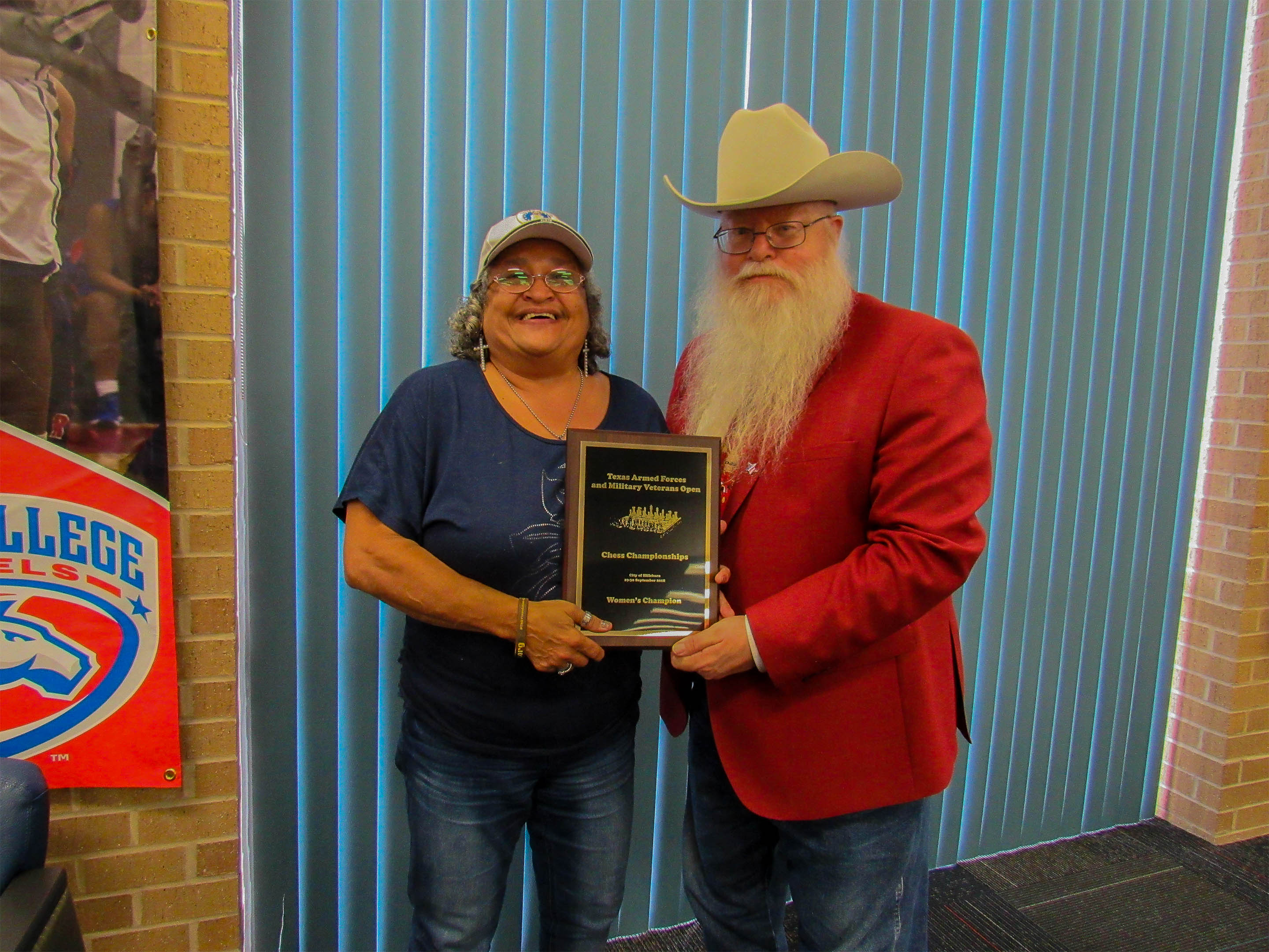 Air Force/Marines Retiree Clarese Roberts (left in the photo) was crowned Texas Armed Forces Women’s Champion by Jim Hollingsworth (right), Chief Organizer.  Photo by Sheryl McBroom.