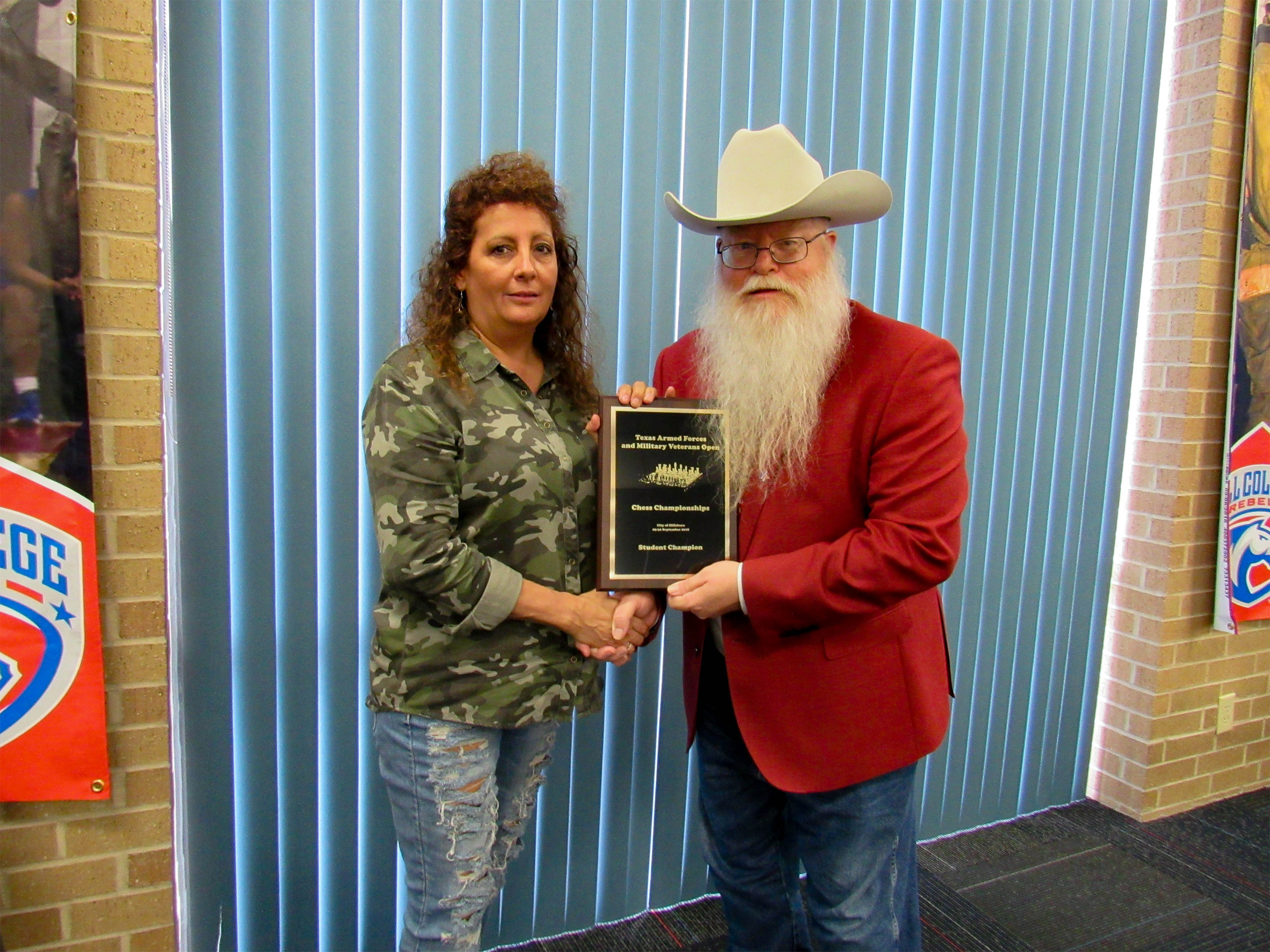 Sheryl McBroom (left in the photo) is awarded the title of Texas Armed Forces Student Champion by Chief Organizer Jim Hollingsworth (right).  Photo by Clarese Roberts.